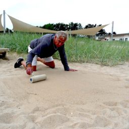 Kreidespray-Aktion am Strand: Untergrund festdrücken