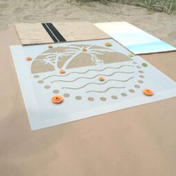 Kreidespray-Aktion am Strand: Schablone beschweten und Abdeckpappe auslegen
