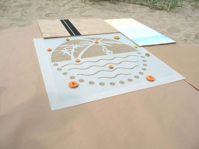 Kreidespray-Aktion am Strand: Schablone beschweten und Abdeckpappe auslegen
