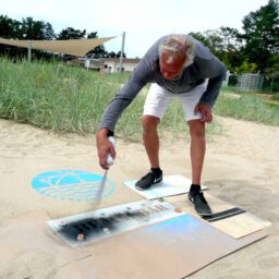 Kreidespray-Aktion am Strand: Schwarzes Kreidespray für die Textschablone