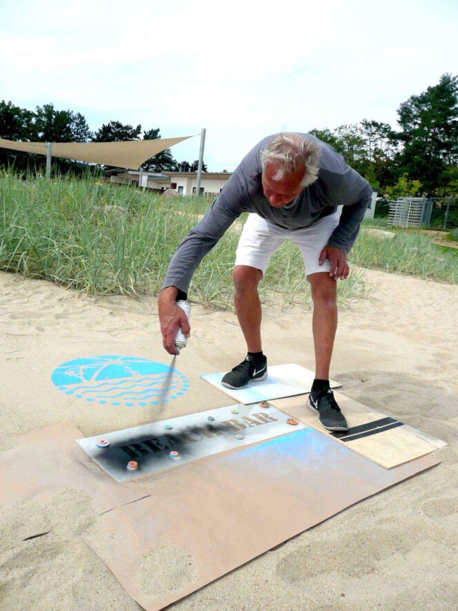 Kreidespray-Aktion am Strand: Schwarzes Kreidespray für die Textschablone