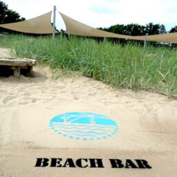 Kreidespray-Aktion am Strand: Logo mit Schriftzug