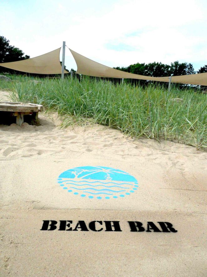 Kreidespray-Aktion am Strand: Logo mit Schriftzug