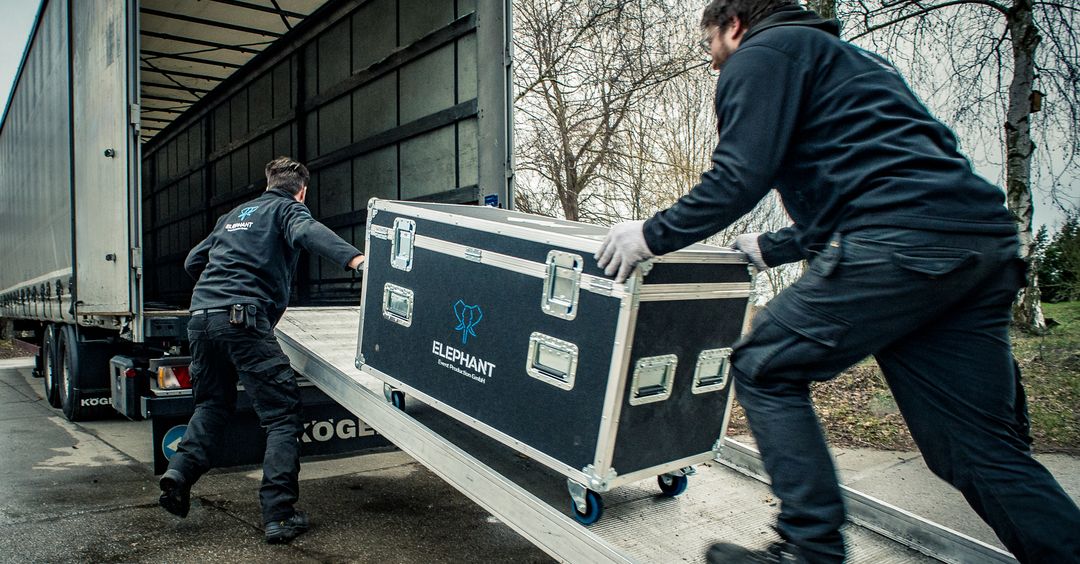 Das Elephant Team schiebt eine Transportkiste auf einen LKW